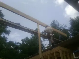 Carpenter setting a ridge beam over a new addition frame — Ice Dam Removal by Roofing Brothers in Allison Park