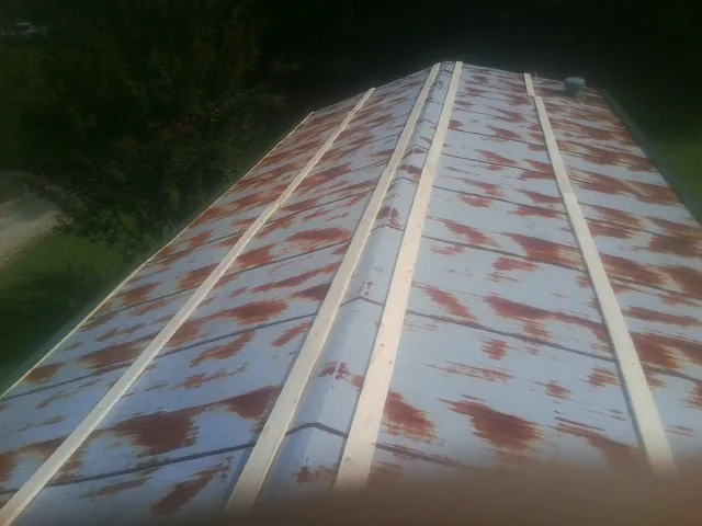 Rusted metal roof panels with new wood purlins before replacement — Storm Damage Roof Repair in Allison Park by Roofing Brothers