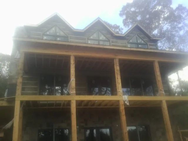 Dormers and porch framing on a large log home under construction — Roof Coating work by our crew in Allison Park