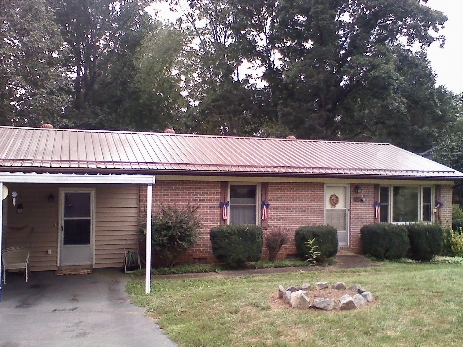 Bronze metal roof and carport on a brick ranch home — Roof Repair work by our crew in Allison Park